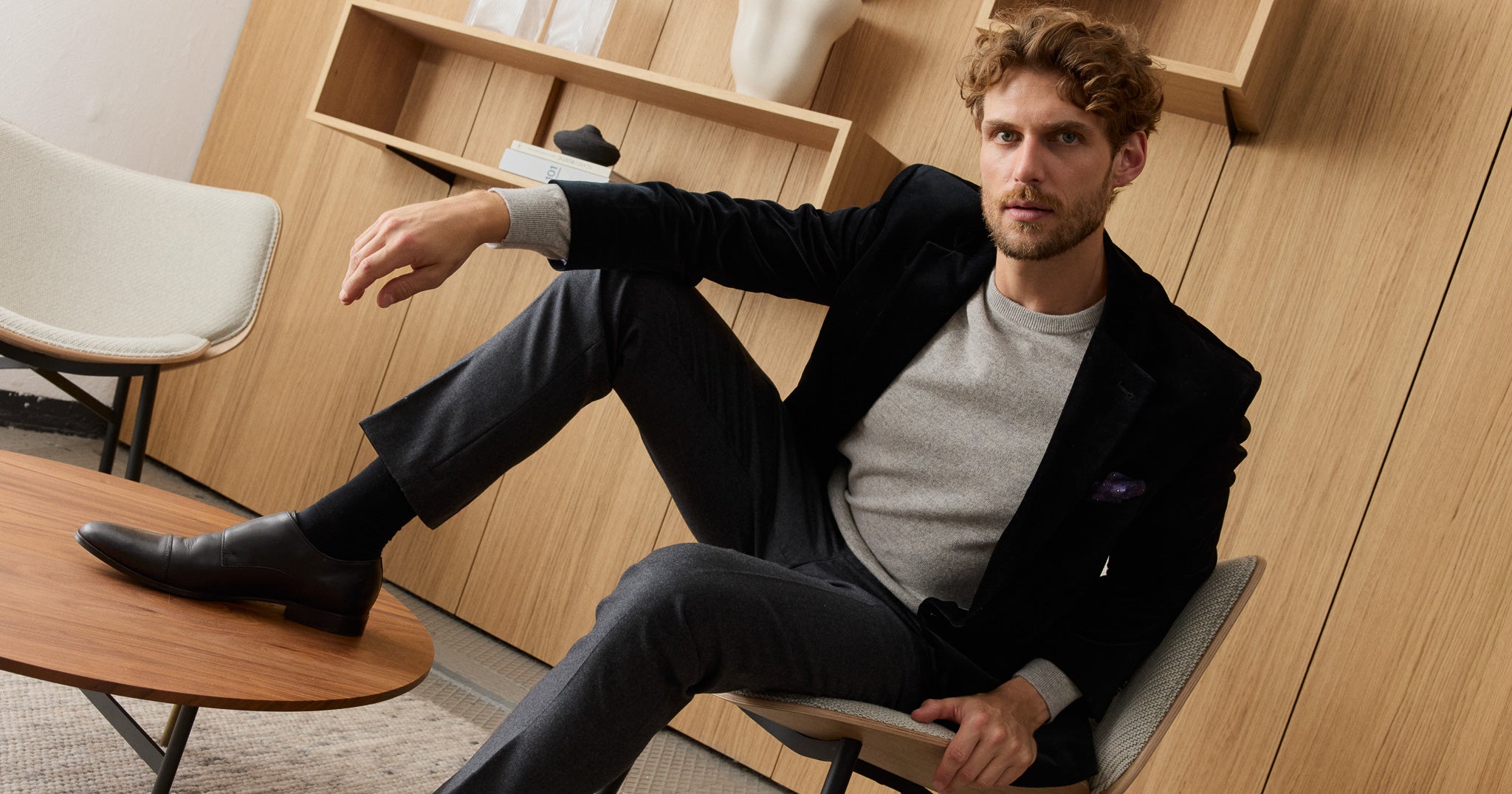 Mann in eleganter Herrenmode sitzend.