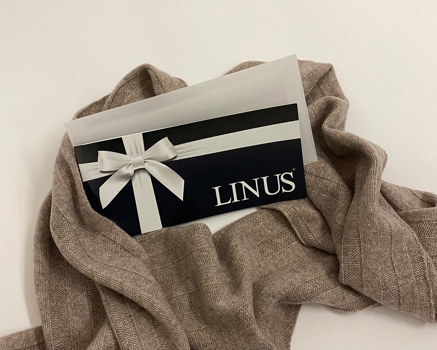 Geschenkbox auf beigem Schal.