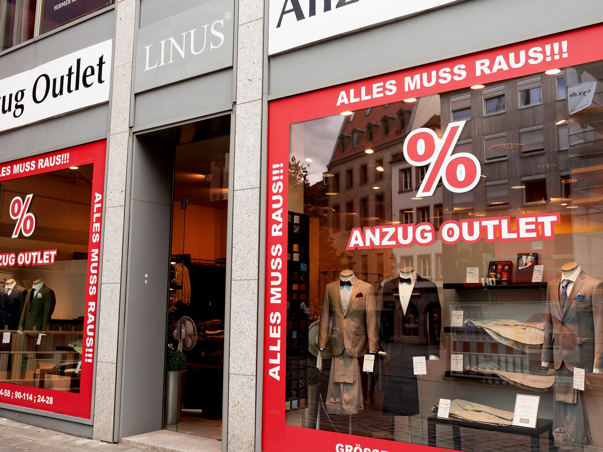 Schaufenster mit Anzügen und Rabatten.