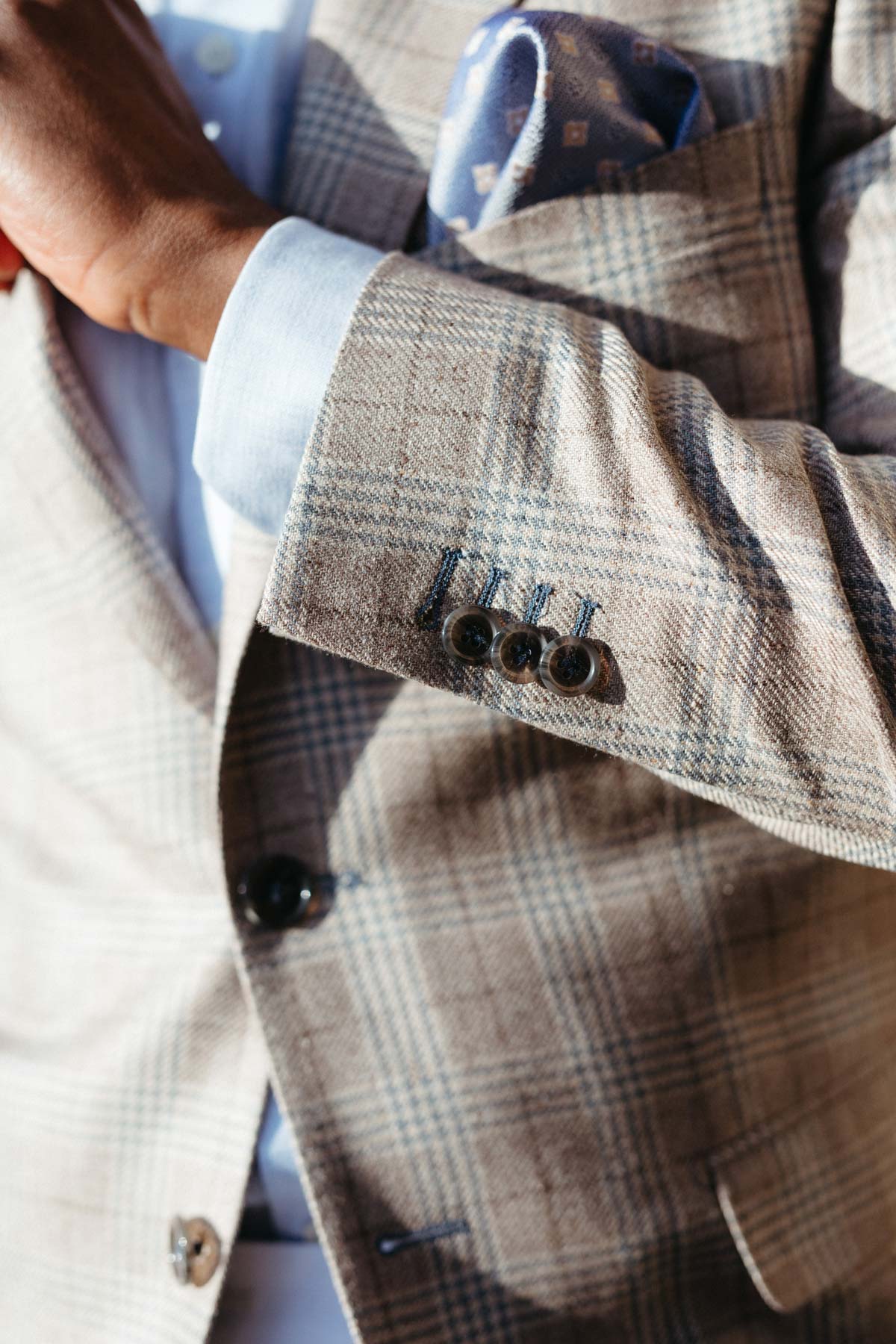 Mann im karierten Anzug mit Einstecktuch und Hemd.