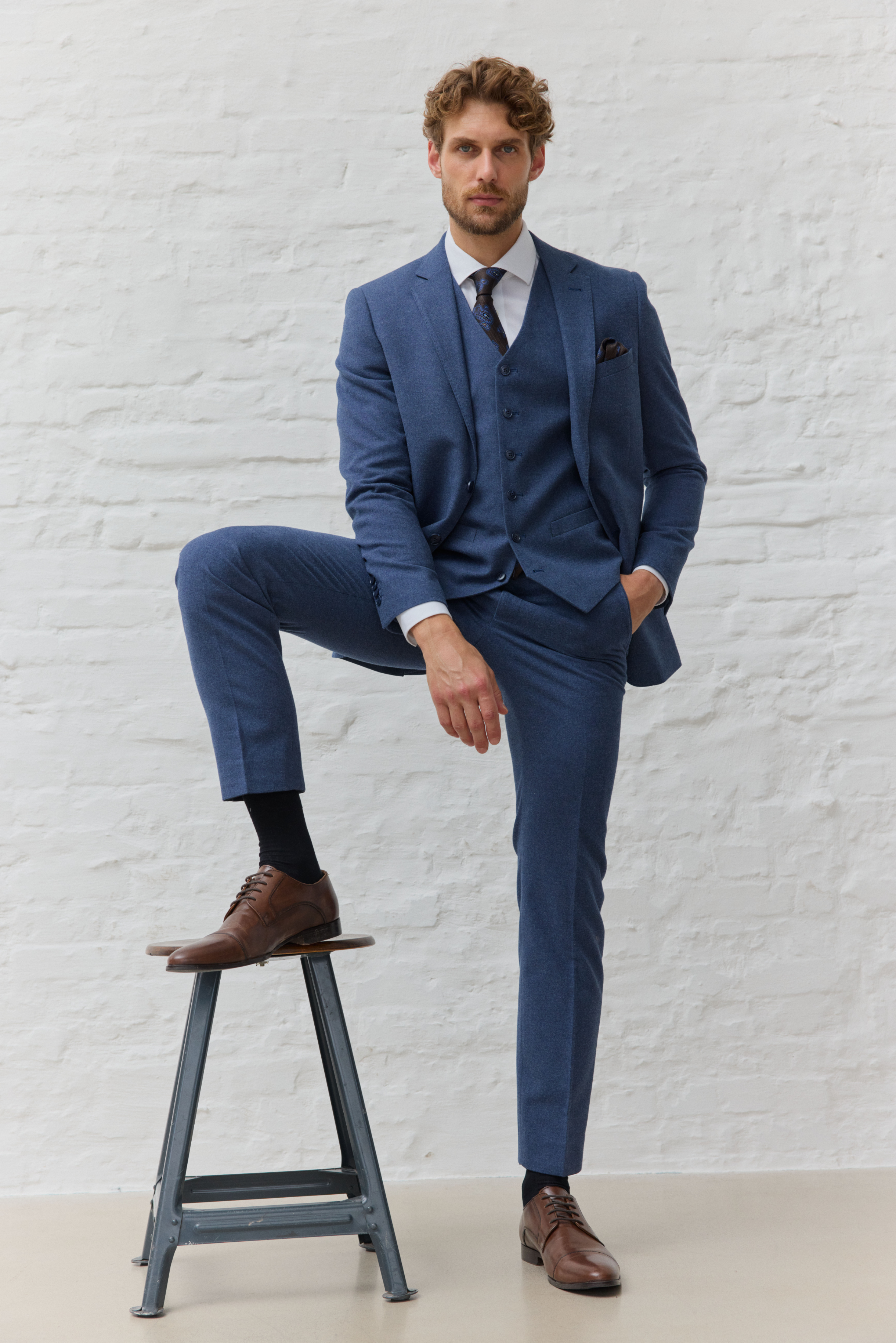 Mann in blauem Anzug mit braunen Lederschuhen.