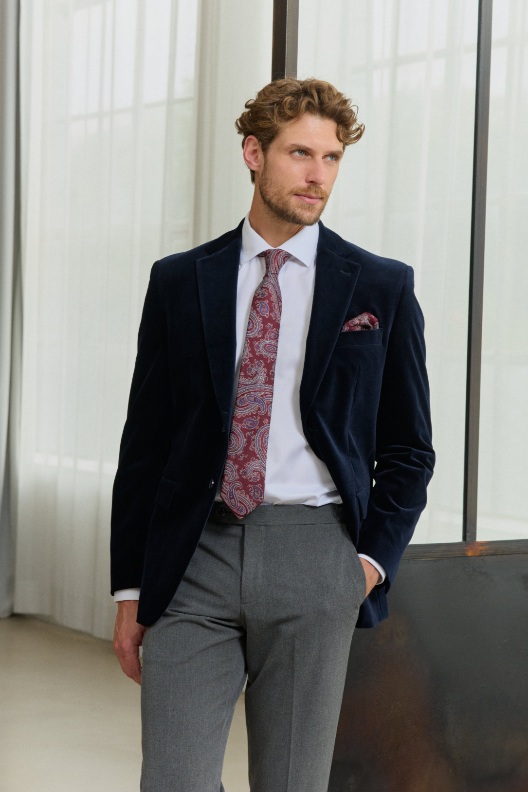 Mann in Anzug mit gemusterter Krawatte und Einstecktuch.