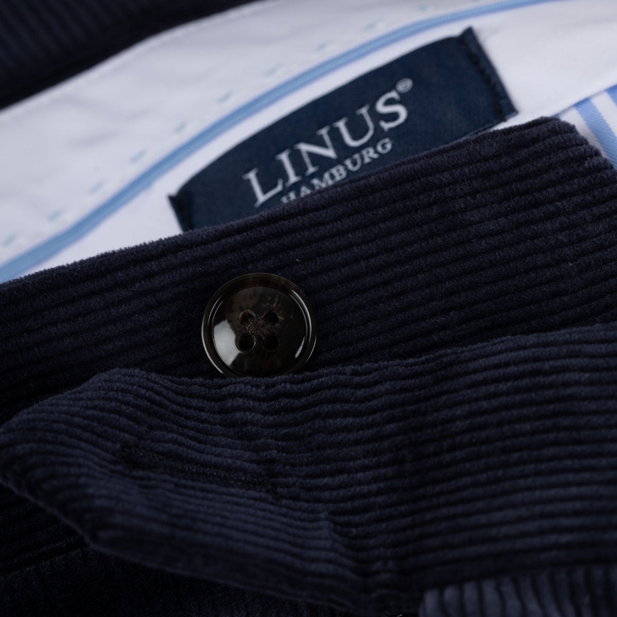 Dunkler Cordanzug mit LINUS-Label.