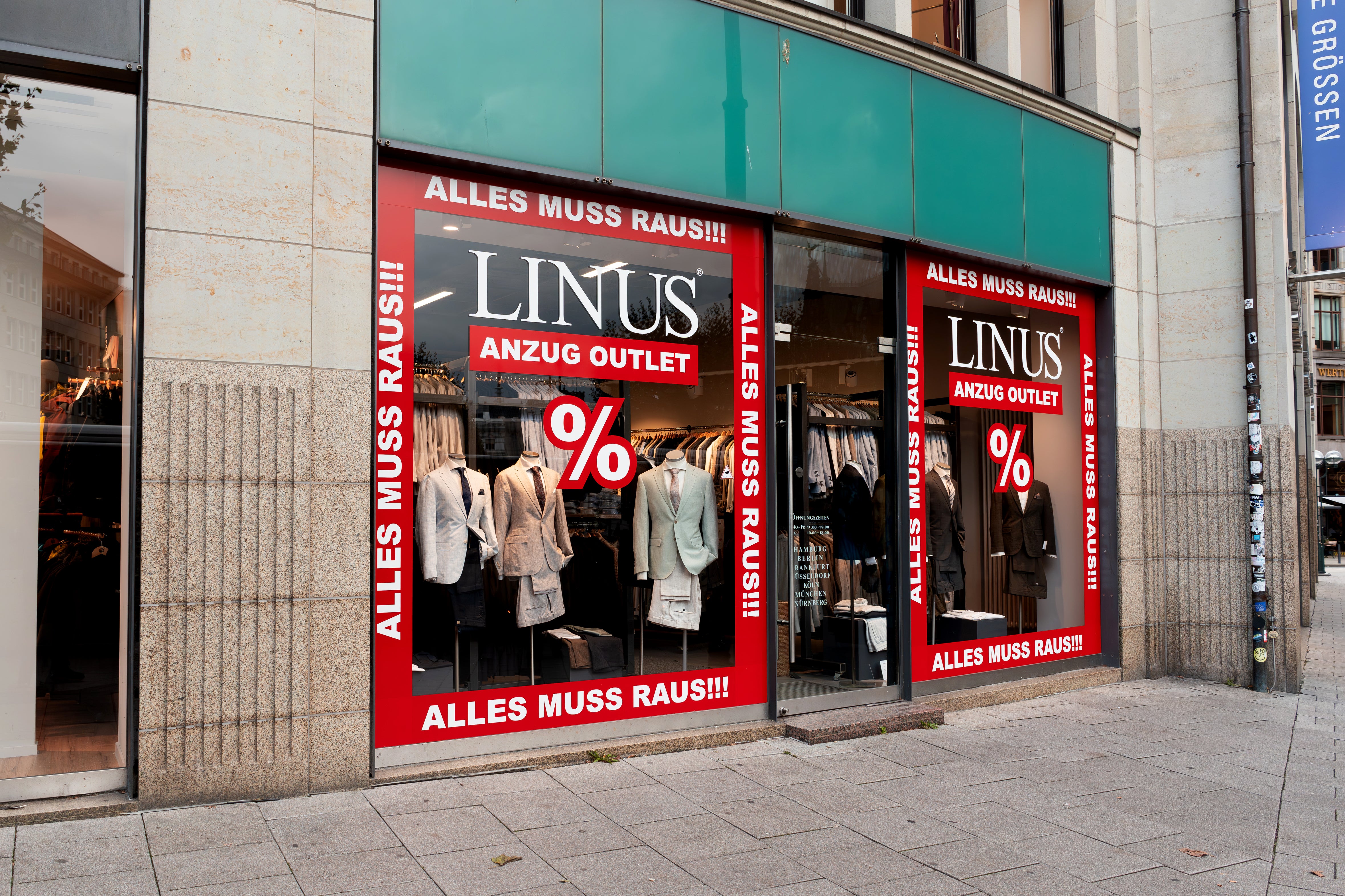 Schaufenster mit Anzügen und Rabatten.
