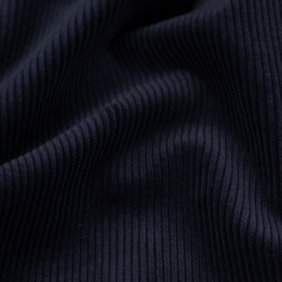 Dunkler, gerippter Stoff in Nahaufnahme.