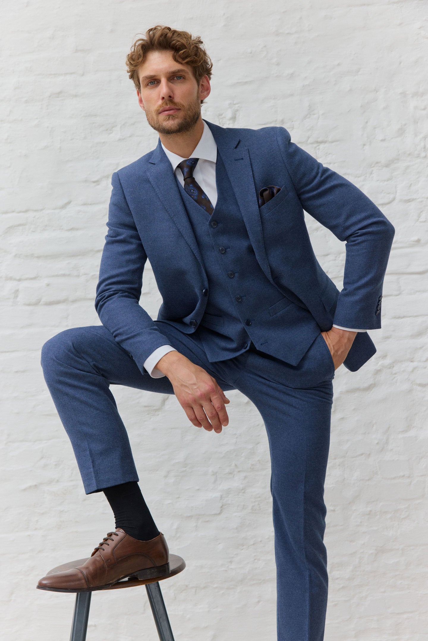 Mann in blauem Anzug mit braunen Lederschuhen.