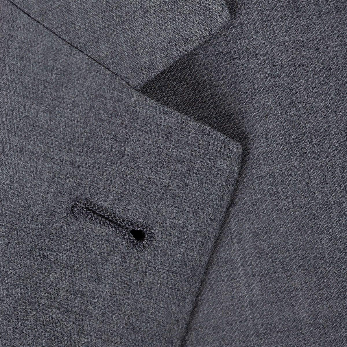 Grauer Anzugstoff mit Knopfloch.